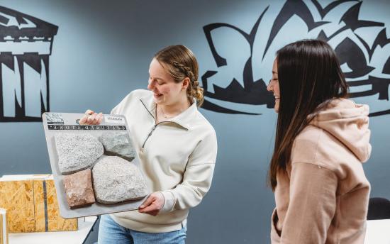 Two students reviewing samples of stone for the architectural drafting and design program